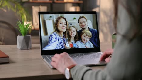 Girl-Waving-Her-Hand-And-Video-Chatting-With-Happy-Family-On-Laptop-Through-Webcam