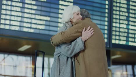 älteres-Paar-Umarmt-Sich-In-Einer-Emotionalen-Begegnung-Am-Flughafen,-Nachdem-Sie-Sich-Lange-Nicht-Gesehen-Haben
