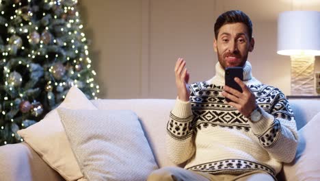 Portrait-Of-Joyful-Young-Man-Smiling-With-Surprised-Face-Tapping-On-Cell-Phone-Feeling-Excited-And-Happy-Winning-Christmas-Lottery