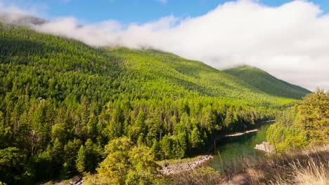 Time-Lapse-Clouds-Travel-Over-A-River-And-Forested-Hillside