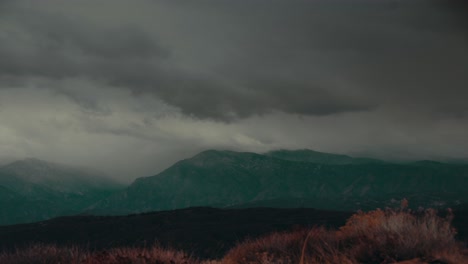 Time-Lapse-Storm-Clouds-Travel-Over-A-Hillside-And-Mountains