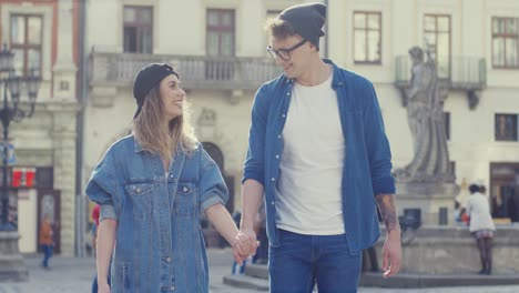 Hipster-Couple-Walking-And-Holding-Hands-In-The-Street