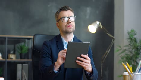 Hombre-De-Negocios-Con-Gafas-Usando-Tableta-En-La-Oficina-1
