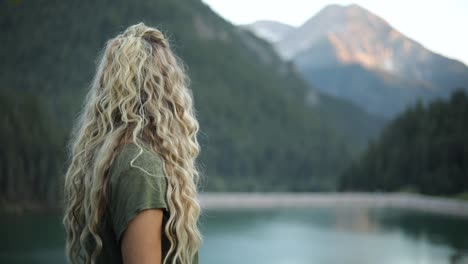 Slow-Motion-Shot-of-a-happy-beautiful-blonde-female-overlooking-a-gorgeous-scene-in-the-mountains