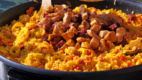 Sequence-Shot-Making-Delicious-Paella,-Adding-Chicken-And-Chorizo