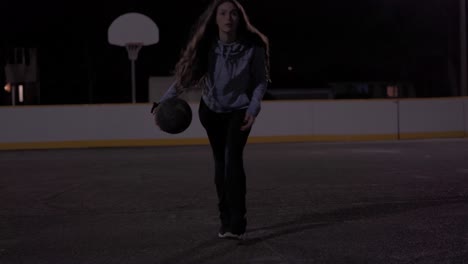 Epic-slow-motion-shot-of-teenage-girl-shooting-basketball-at-night-outside,-backlit