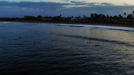 Aerial-Orbit-View-Of-Surfers-At-Sunrise-Waiting-For-Wave
