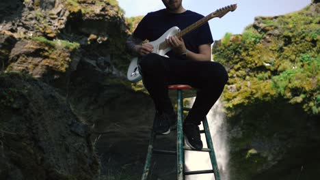 Mann-Spielt-Gitarre-Vor-Einem-Wunderschönen-Wasserfall-In-Island-2