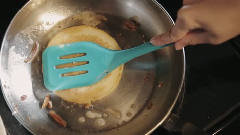 Pressing-Down-The-Pancake-With-A-Plastic-Spatula-To-Cook-It-Faster---Close-Up-Shot