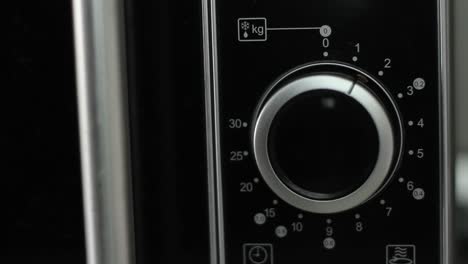 Setting-microwave-timer-to-one-minute-and-turning-microwave-off---close-up-shot---front-view