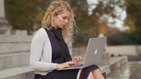 An-Attractive-Woman-Woking-On-A-Laptop-Outside-And-Is-Happy-To-Finish-A-Piece-Of-Work