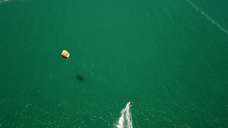 High-altitude-top-down-drone-shot-of-Kite-surfer-in-turquoise-Atlantic-ocean
