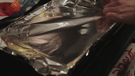 Chef-Covering-The-Baking-Pan-With-Aluminum-Foil-Wrap---Closeup-Shot