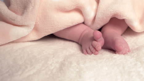 Beautiful-Baby-newborn-is-lying-in-bed-and-shows-hands-and-feet,-mother-fandles-with-baby-and-covers-her-up-with-a-cosy-coverlet,4k-60p-Apple-ProRes422,-with-external-Atoms-recorder-6