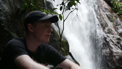 Junger-Kaukasischer-Mann-Ruht-Neben-Einem-Wasserfall-Auf-Seiner-Wanderung-Durch-Den-Regenwald-Auf-Ihla-Grande-Brasilien