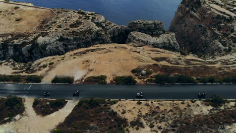 Tourists-Riding-ATVs-Enjoying-Drive-Along-Dramatic-Coastal-Road-Gozo,-Malta