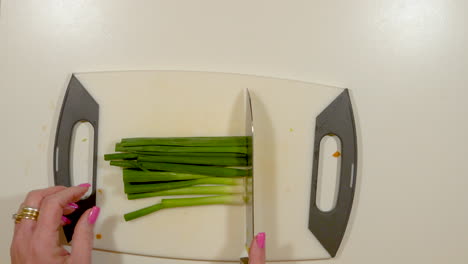 Woman's-hands-chopping-green-onions---speed-ramp-up-and-down