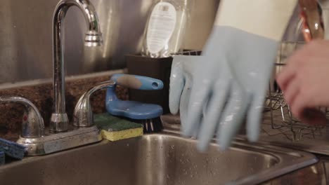 Removing-Off-The-Wet-Gloves-And-Hanging-Them-On-The-Dish-Rack---Close-Up-Shot