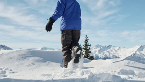 Niño-Con-Traje-De-Snowboard-Caminando-Por-El-Ventisquero-En-El-Paisaje-Alpino