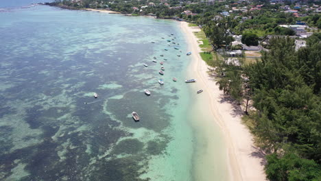 Drone-Vuela-Lentamente-Hacia-Una-Hermosa-Playa-Y-Aguas-Claras-Con-Muchos-Pequeños-Barcos-De-Pesca-Cerca-De-La-Ciudad-De-Albion-En-La-Isla-De-Mauricio