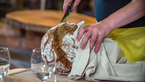 Chef-cuts-black-bread-on-cutting-board-Podvelka,-Slovenia,-slowmo-closeup