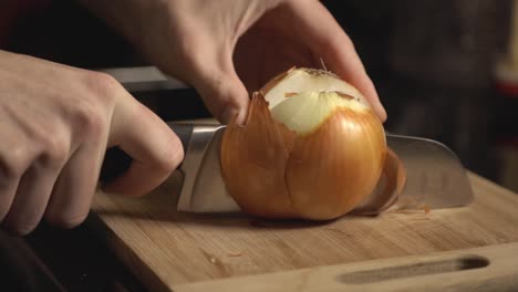 Slicing-A-Whole-White-Onion-Using-A-Knife-On-Wooden-Chopping-Board