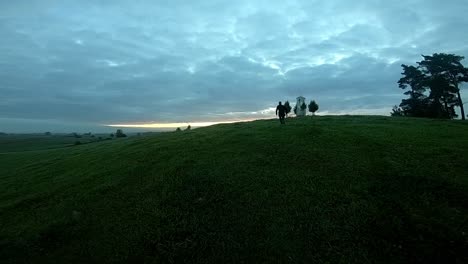 A-slow-drone-shot-following-a-teenager-running-up-the-hill-during-sunrise