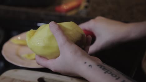A-Woman-Slicing-A-Ripe-Mango-With-Red-Knife-And-Placing-It-In-A-Plate-At-The-Kitchen---Close-Up-Shot