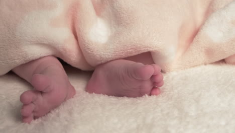 Beautiful-Baby-newborn-is-lying-in-bed-and-shows-hands-and-feet,-mother-fandles-with-baby-and-covers-her-up-with-a-cosy-coverlet,4k-60p-Apple-ProRes422,-with-external-Atoms-recorder-9