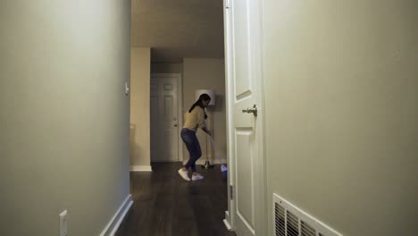 Hispanic,-Latina-woman-brooms-her-apartament