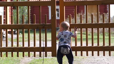 Toddler-opens-gate-and-walks-in-garden
