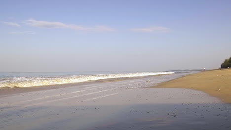 Low-angle-shot-tropical-waves-and-Man-Jogging-Along-Beach,-Early-Morning-run