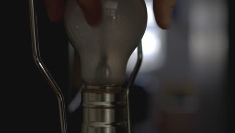 Installing-A-Light-Bulb-Into-A-Socket-And-Lighting-It---closeup-shot