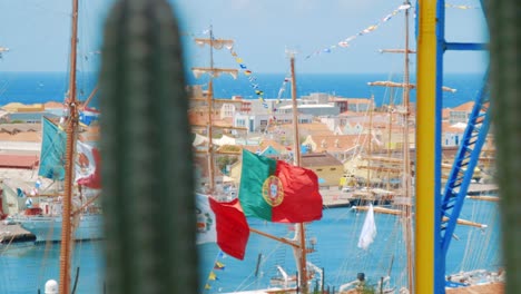 Barcos-Atracados-En-El-Puerto-Con-Banderas-De-México,-Perú-Y-Portugal-Volando-En-La-Brisa-En-Un-Día-Claro-Con-Cactus-Desenfocados-En-Primer-Plano
