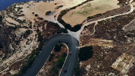 Aerial-Flyover-Quad-Bike-Excursion-On-Winding-Coastal-Road-Gozo,-Malta