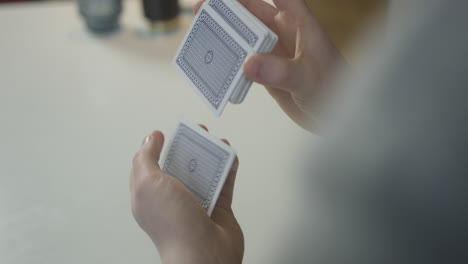 Mann-Mischt-Kartenspiel-Für-Einen-Zaubertrick-In-Seinem-Wohnzimmer-über-Die-Schulter