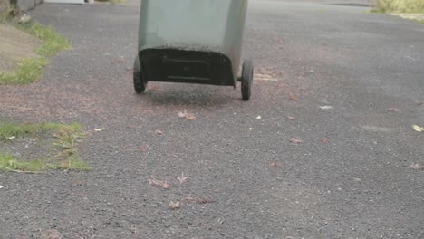 Moving-green-recycling-wheelie-bin-for-waste-collection