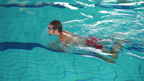 Hombre-Caucásico-Nadando-En-La-Piscina-Usando-La-Técnica-De-Braza-1