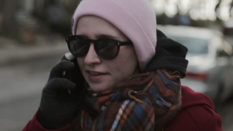 Young-Woman-Wearing-Maroon-Jacket-Talking-To-The-Phone-While-Walking-Along-The-Street-in-Canada---Close-Up-Shot