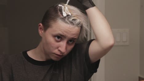 A-Young-Lady-Applying-Hair-Bleach-Cream-At-Home---Close-Up-Shot