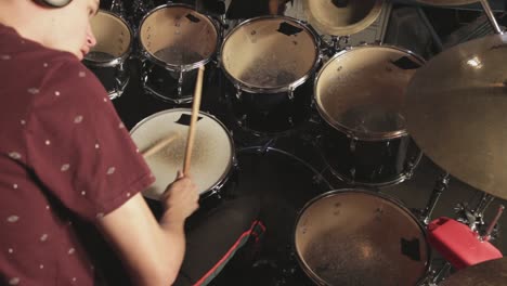 Young-talented-drummer-playing-his-drum-set-and-practicing-While-Using-Headset---Close-Up-Shot