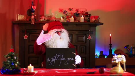 Santa-Claus-Showing-A-Gift-For-You-Note-On-Chalk-Blackboard
