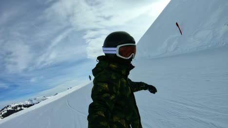 Ein-Kind,-Das-Mit-Einem-Selfie-Stick-Die-Piste-Hinunter-Snowboardet