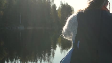 Woman-paddling-canoe-on-beautiful-lake-in-autumn,-rear-view-closeup