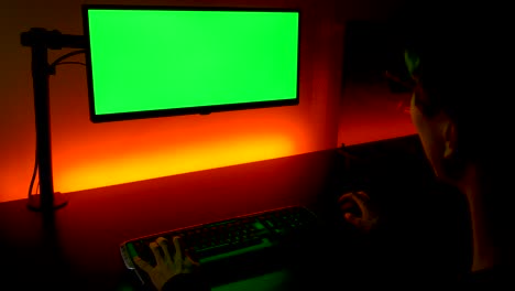 Grüner-Bildschirm:-über-Die-Schulteraufnahme-Eines-Kaukasischen-Mannes,-Der-Vor-Dem-Monitor-Auf-Der-Tastatur-Tippt