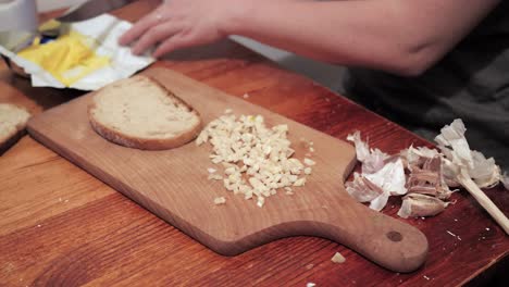 Woman's-hand-takes-a-slice-of-bread,-smears-it-with-butter
