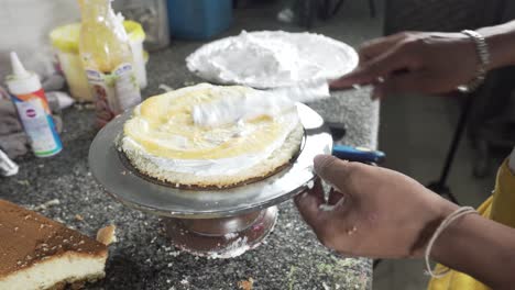 Adding-filling-in-cake-layer,-yellow-jam-on-top-of-whipped-cream,-Close-up