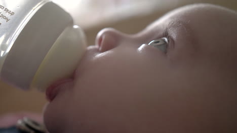 Baby-Infant-is-drinking-some-milk-from-a-bottle-looking-up,-closeup-macro,-FullHD-24p-Apple-ProRes422