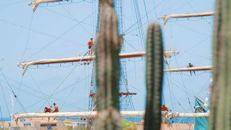 Sailors-checking-on-the-rigging-of-a-tall-ship-while-it-is-docked-in-Curaçao-while-it-is-docked-in-the-harbor