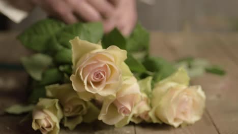 Blumenhändler,-Der-Ein-Band-Um-Einen-Strauß-Rosa-Und-Weißer-Pastellrosen-Bindet
